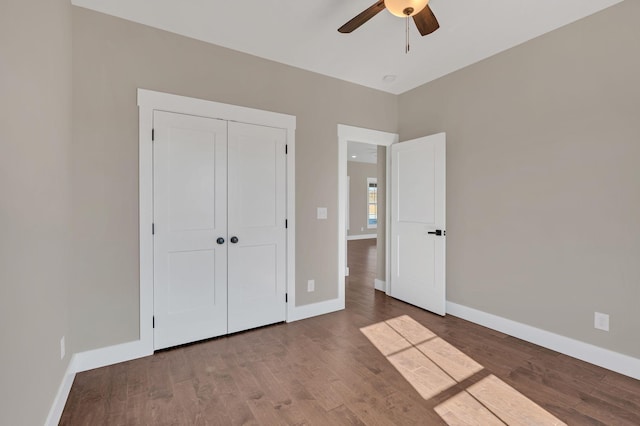 unfurnished bedroom with hardwood / wood-style flooring, ceiling fan, and a closet