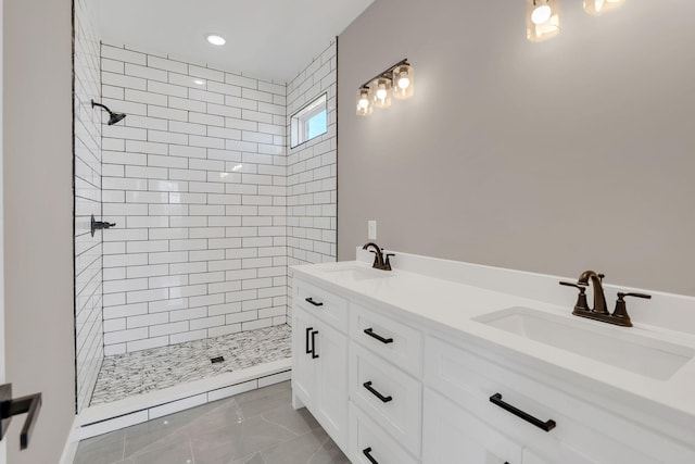 bathroom with vanity and a tile shower