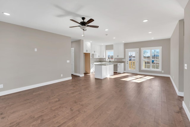 unfurnished living room featuring dark hardwood / wood-style floors and ceiling fan