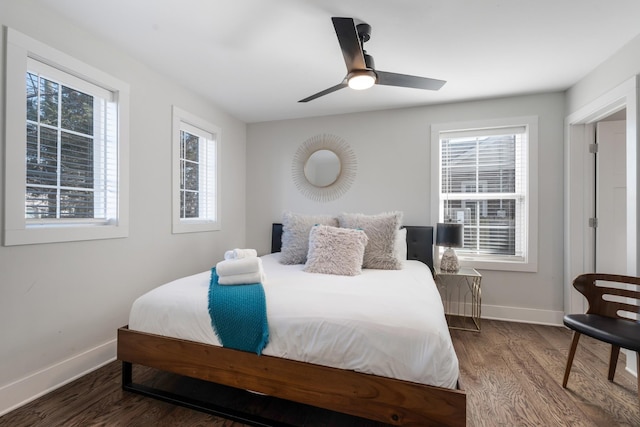 bedroom with dark hardwood / wood-style flooring and ceiling fan