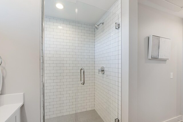 bathroom with a shower with door and vanity