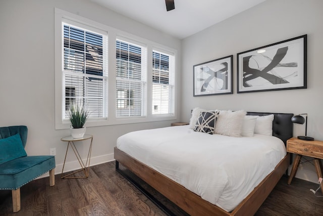 bedroom featuring multiple windows, dark hardwood / wood-style floors, and ceiling fan