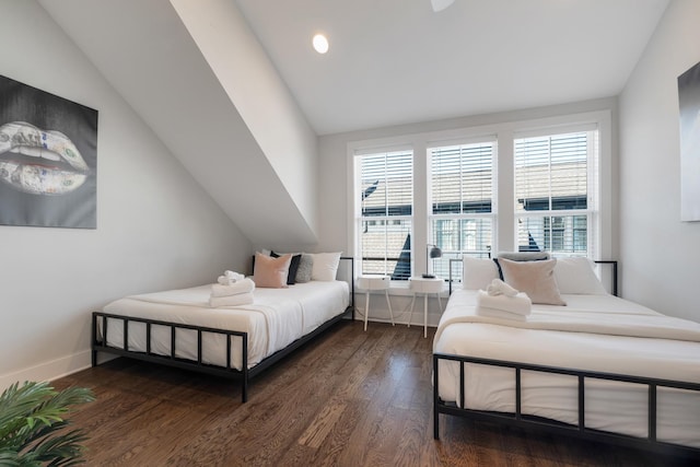 bedroom with dark wood-type flooring and lofted ceiling