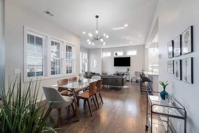 dining space with an inviting chandelier, dark hardwood / wood-style flooring, and sink