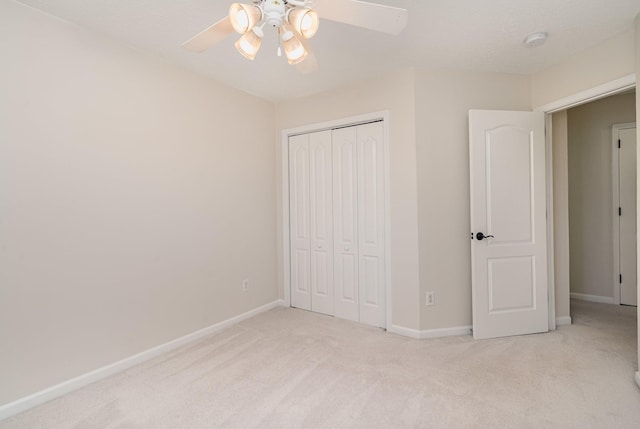 unfurnished bedroom with ceiling fan, light carpet, and a closet