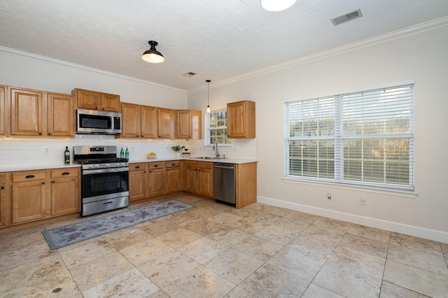 kitchen featuring hanging light fixtures, crown molding, appliances with stainless steel finishes, and sink