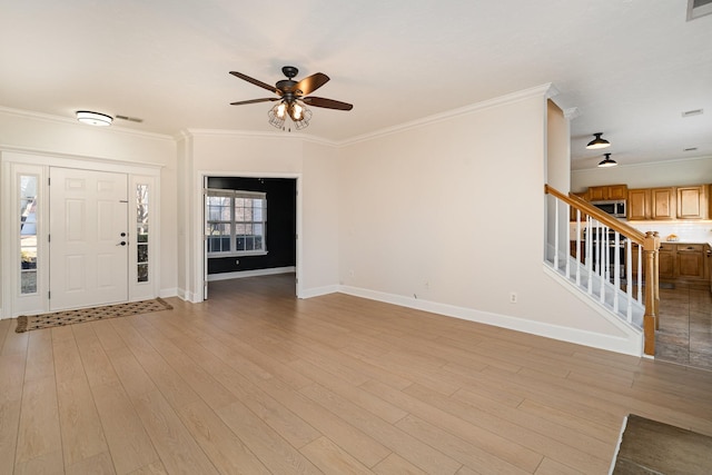 entryway with ornamental molding, ceiling fan, and light wood-type flooring