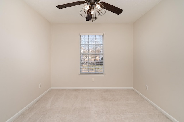 spare room with light colored carpet and ceiling fan