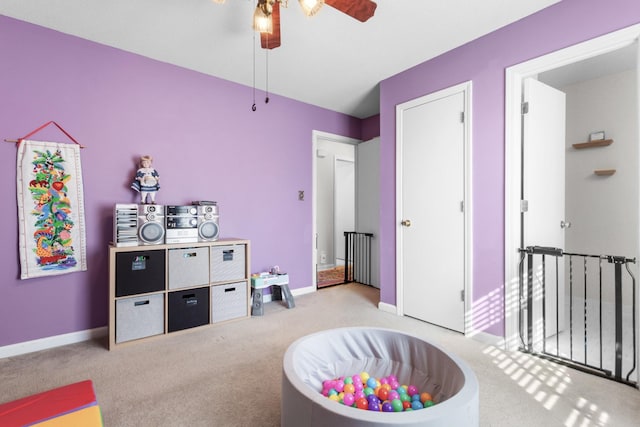 recreation room featuring light carpet and ceiling fan