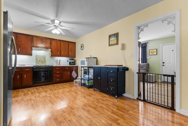 kitchen featuring light hardwood / wood-style floors, stainless steel fridge with ice dispenser, a textured ceiling, and black range with electric cooktop