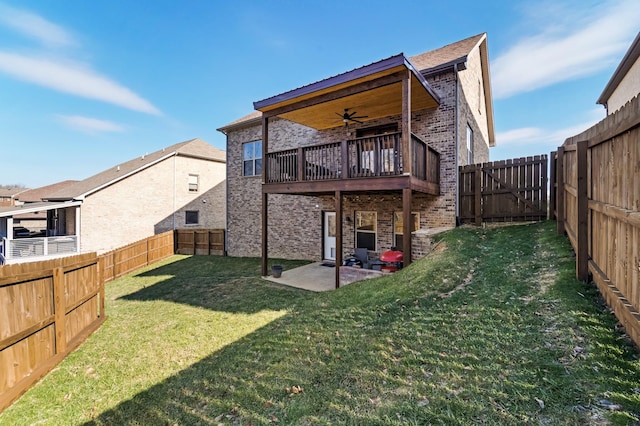 rear view of property featuring a wooden deck, a yard, a patio, and ceiling fan