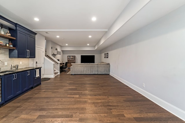 kitchen featuring blue cabinetry, dark hardwood / wood-style flooring, sink, and tasteful backsplash