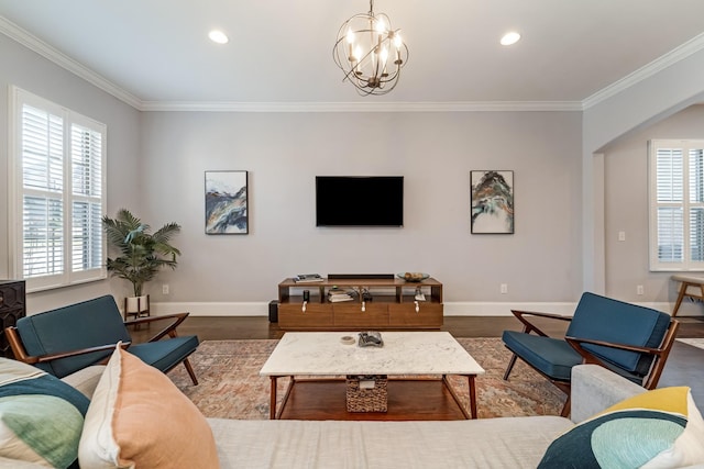 living room with dark wood-type flooring, crown molding, and a notable chandelier