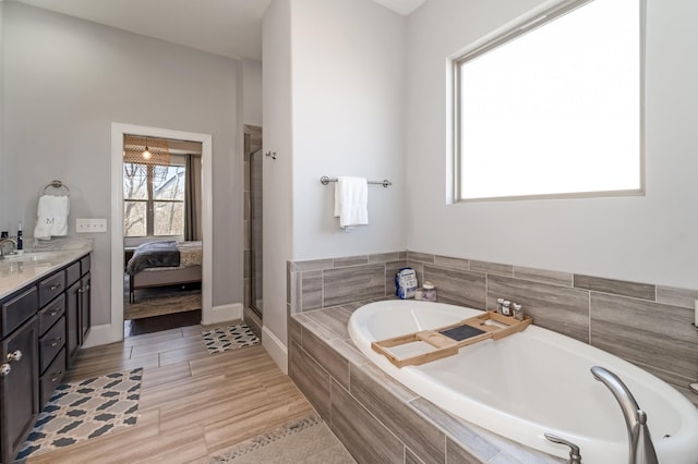 bathroom with a relaxing tiled tub and vanity