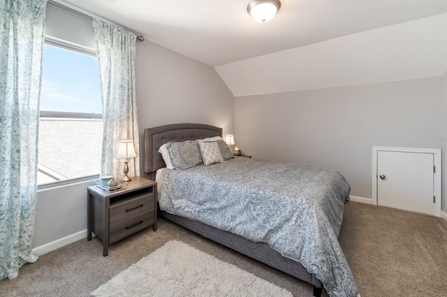 bedroom with multiple windows, lofted ceiling, and light carpet