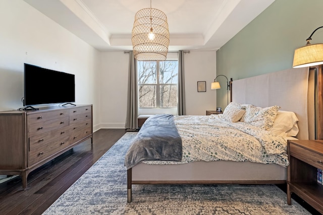 bedroom featuring dark wood-type flooring, ornamental molding, and a raised ceiling