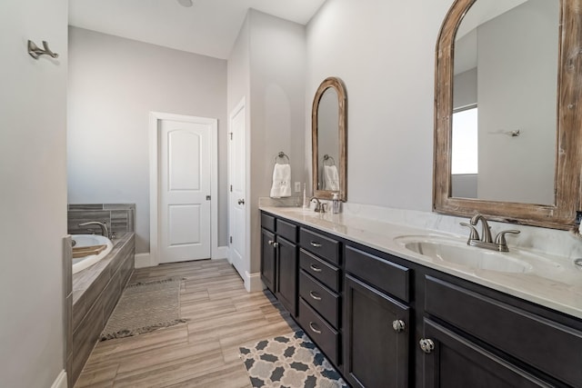 bathroom with tiled tub and vanity