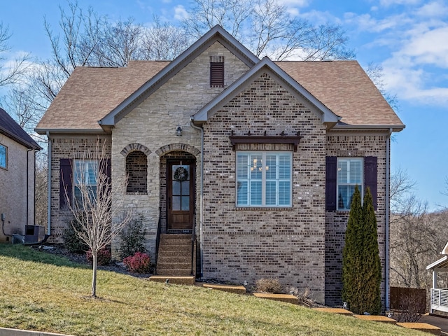 view of front of house with central AC unit and a front yard