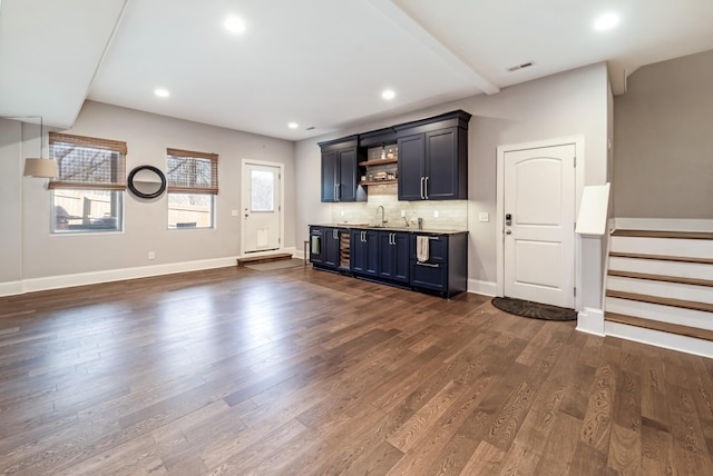 interior space with tasteful backsplash, sink, and dark hardwood / wood-style flooring