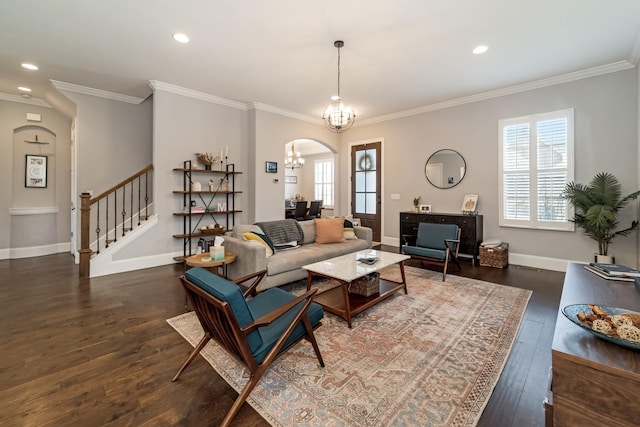 living room featuring crown molding, dark hardwood / wood-style floors, a chandelier, and a wealth of natural light