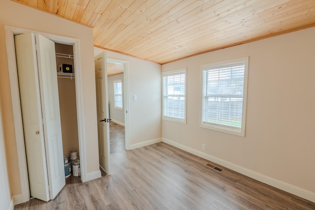 unfurnished bedroom with crown molding, light hardwood / wood-style floors, a closet, and wooden ceiling