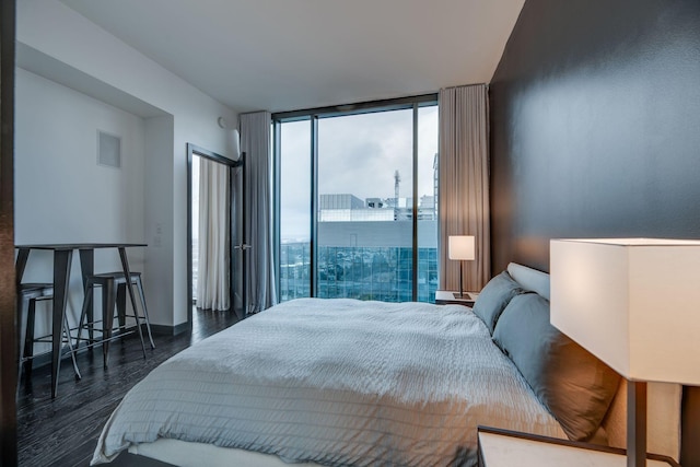 bedroom with floor to ceiling windows and dark hardwood / wood-style floors