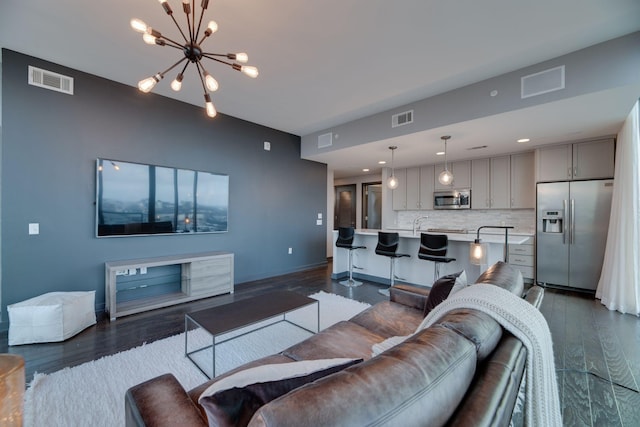 living room with dark hardwood / wood-style flooring and an inviting chandelier