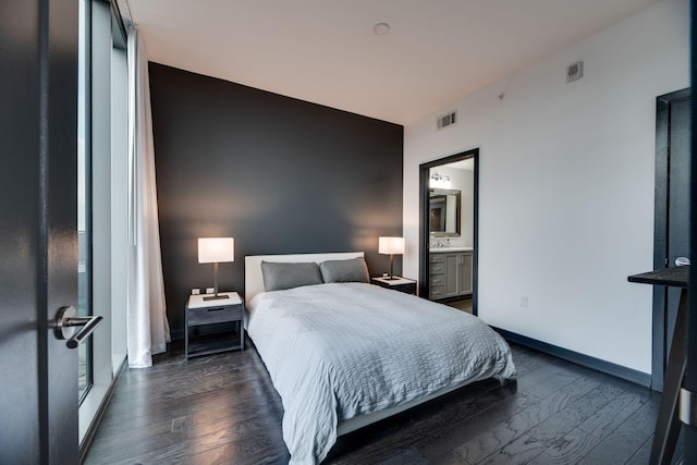 bedroom with dark wood-type flooring and ensuite bath