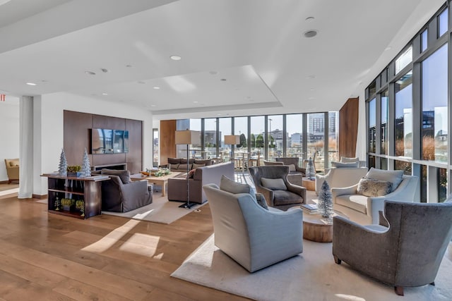 living room with expansive windows and light hardwood / wood-style floors