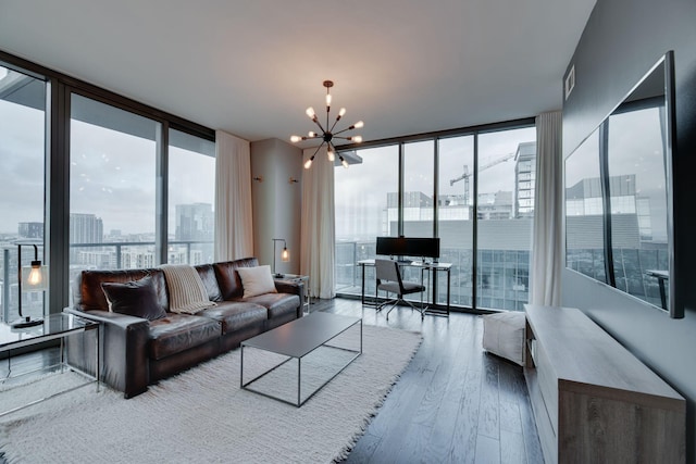 living room featuring wood-type flooring, plenty of natural light, an inviting chandelier, and a wall of windows