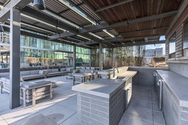 view of patio / terrace with outdoor lounge area, sink, and an outdoor kitchen