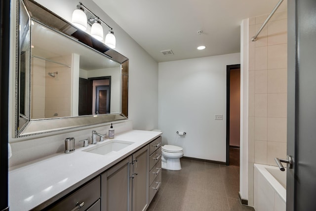 full bathroom featuring vanity, tiled shower / bath combo, and toilet