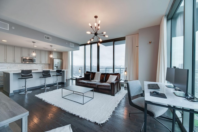 living room with floor to ceiling windows, a notable chandelier, and dark hardwood / wood-style flooring