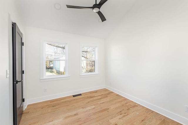 empty room featuring vaulted ceiling, a healthy amount of sunlight, and light hardwood / wood-style floors