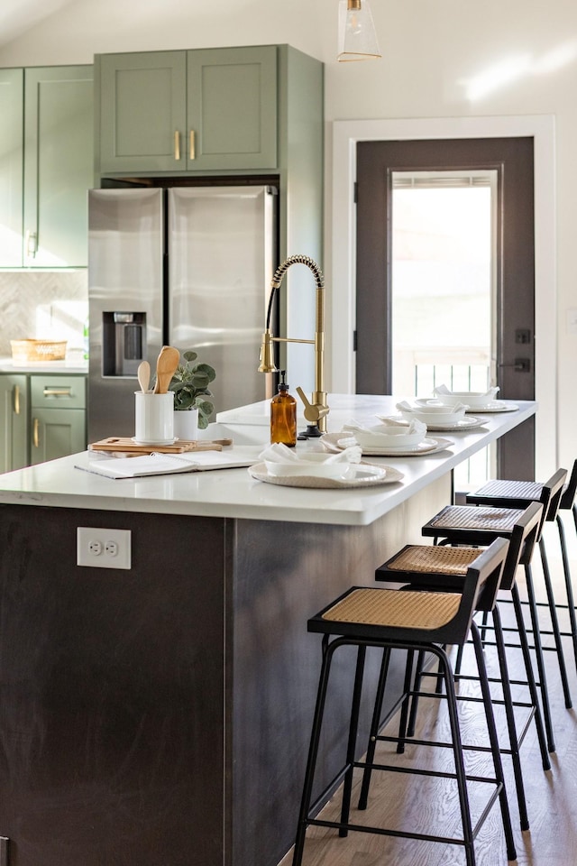 kitchen with decorative backsplash, stainless steel fridge, dark hardwood / wood-style flooring, and green cabinetry