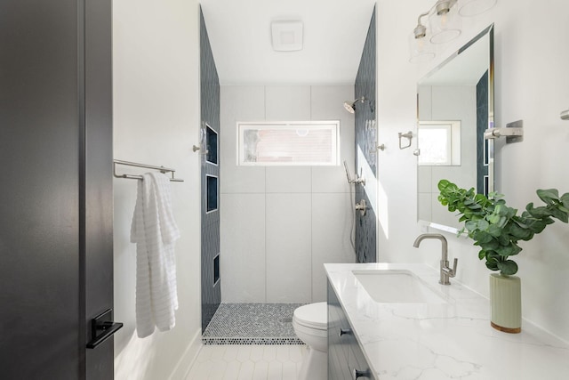 bathroom with a shower, vanity, tile patterned floors, and toilet