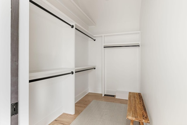 spacious closet featuring a barn door and light hardwood / wood-style floors