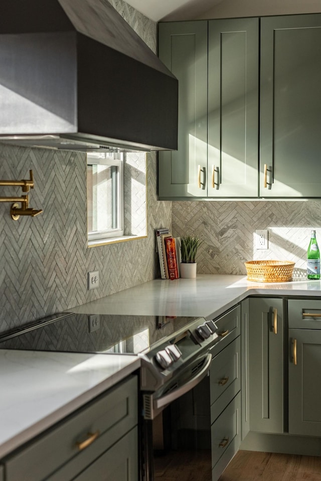 kitchen featuring electric stove, dark hardwood / wood-style floors, and backsplash