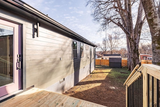 view of side of property featuring a deck and a storage unit