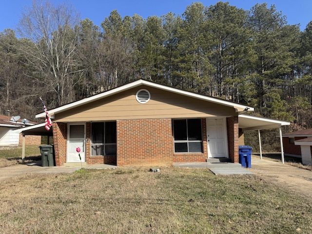 ranch-style house featuring a carport and a front lawn