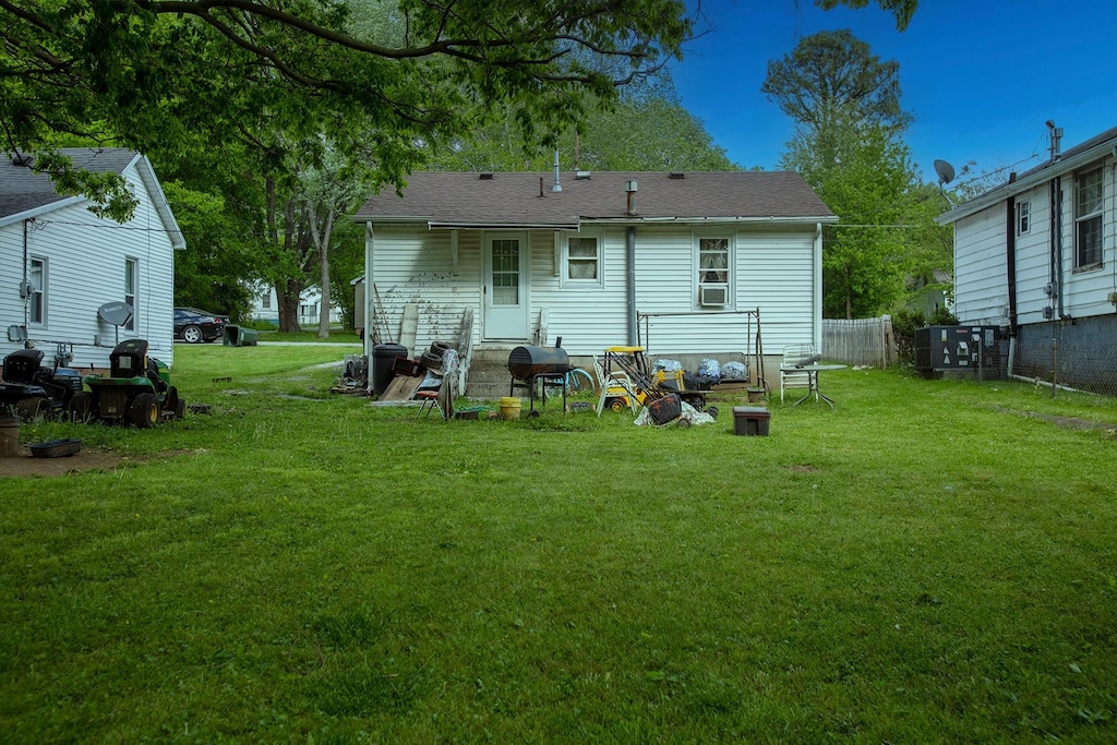 rear view of property with a yard