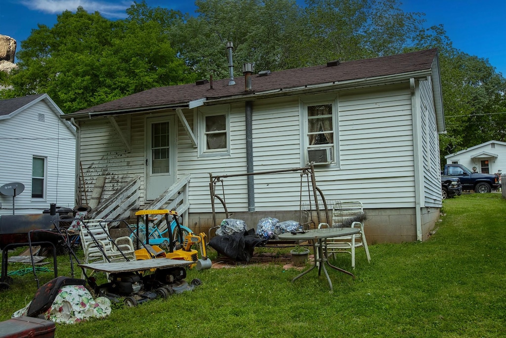 rear view of property with a lawn