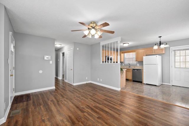 unfurnished living room with visible vents, baseboards, dark wood finished floors, a sink, and ceiling fan with notable chandelier