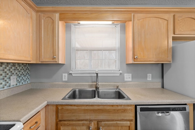 kitchen featuring light brown cabinets, light countertops, stainless steel dishwasher, and a sink