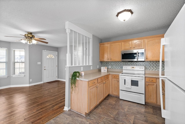 kitchen featuring white appliances, baseboards, ceiling fan, light countertops, and backsplash