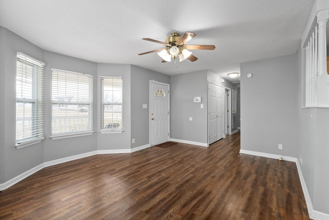 entryway featuring dark wood-type flooring, a healthy amount of sunlight, ceiling fan, and baseboards