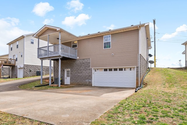 exterior space with concrete driveway, a lawn, and an attached garage