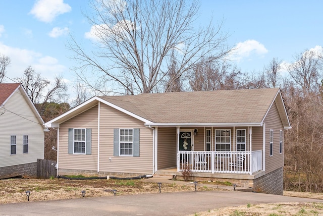 ranch-style house featuring covered porch and roof with shingles