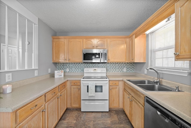 kitchen featuring a sink, light countertops, appliances with stainless steel finishes, backsplash, and light brown cabinetry