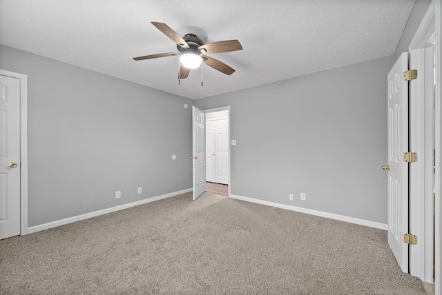 unfurnished bedroom with carpet flooring, ceiling fan, a textured ceiling, and baseboards